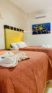 una habitación de hotel con 2 camas y un cuadro en la pared en CASA DELFINES RIO LAGARTOS, en Río Lagartos