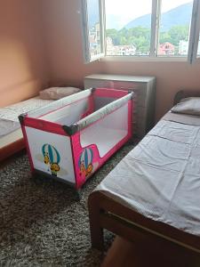 a kids bedroom with two beds and a crib at Dena apartman Tivat in Tivat