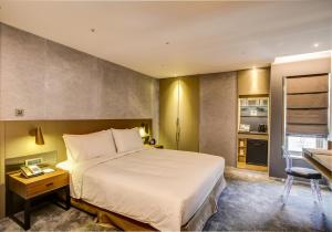a hotel room with a bed and a desk at CHECK inn Taipei Nanjing in Taipei