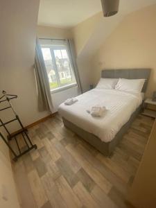 Un dormitorio con una cama grande y una ventana en The Meadows 4 bedroom, en Buncrana