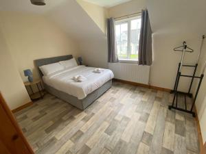 1 dormitorio con 1 cama y suelo de madera en The Meadows 4 bedroom, en Buncrana