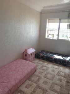 a bedroom with two beds and a pink house at Appartement Meublé AIN SEBAA in Aïn Sebaa