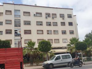 a person riding a motorcycle in front of a building at Appartement Meublé AIN SEBAA in Aïn Sebaa