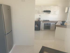 a kitchen with a refrigerator and a stove at Appartement Meublé AIN SEBAA in Aïn Sebaa