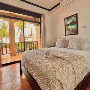 a bedroom with a bed with a view of the ocean at The Backyard Beachfront Hotel in Jacó