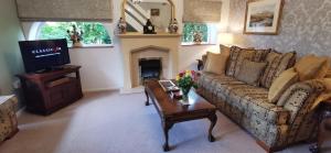 North ThoresbyにあるThe Saddlery Holiday Cottage - Near Wolds And Coastのソファとテレビのあるリビングルーム