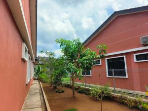 a red house with a tree in front of it at Homestay Mak Abah in Kuantan