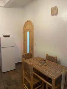 a kitchen with a table with chairs and a refrigerator at Casa Hassan in Asilah