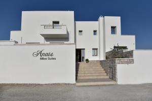 a white building with stairs and a sign on it at Anais Milos Suites in Adamas
