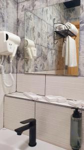 La salle de bains est pourvue d'un miroir et d'un sèche-cheveux. dans l'établissement Hotel BaniHills Tbilisi, à Tbilissi