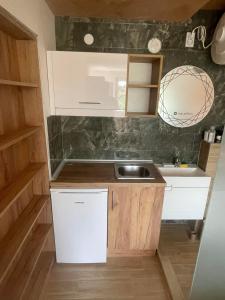 a small kitchen with white cabinets and a sink at Apartments "Predah kod Baraća" in Niš