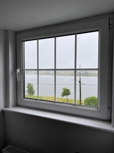 a window in a room with a view of the water at The Light House in Galway