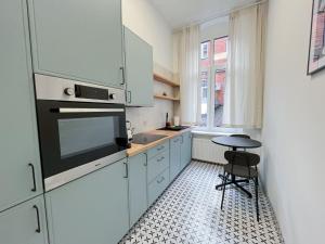 eine Küche mit weißen Schränken, einem Tisch und einem Stuhl in der Unterkunft Apartamenty Drukarnia in Toruń + 16 Fotos