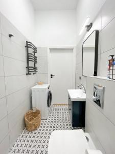 ein Badezimmer mit Waschbecken und Waschmaschine in der Unterkunft Apartamenty Drukarnia in Toruń