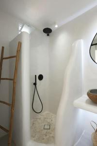 a white room with a shower and a shelf at Syrolia village in Kinion