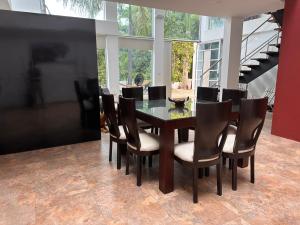 a dining room with a glass table and chairs at Villa campestre Casa Blanca Full House in Agua de Dios