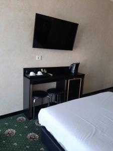 een hotelkamer met een bed en een bureau met een televisie bij Arcadia City Apartments in Odessa