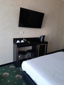 a hotel room with a bed and a desk with a television at Arcadia City Apartments in Odesa