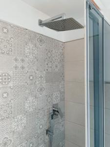 La salle de bains est pourvue d'une douche avec une porte en verre. dans l'établissement Terrazza delle rose, à Nettuno