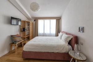 ein kleines Schlafzimmer mit einem Bett und einem Fenster in der Unterkunft Bisu Isola di Sant'Antioco in SantʼAntìoco