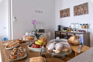 einen Tisch mit vielen verschiedenen Brotsorten und Gebäck in der Unterkunft Bisu Isola di Sant'Antioco in SantʼAntìoco