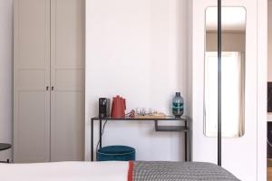 聖安蒂奧科的住宿－Bisu Isola di Sant'Antioco，一间卧室配有一张床和一张桌子及椅子