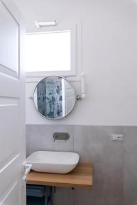 W łazience znajduje się umywalka i lustro. w obiekcie Bisu Isola di Sant'Antioco w mieście SantʼAntìoco