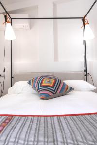 una cama con una almohada a rayas encima en Bisu Isola di Sant'Antioco, en SantʼAntìoco