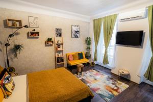 a bedroom with a bed and a chair and a television at Colors of Budapest in Budapest