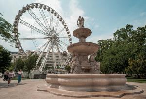 a fountain in front of a ferris wheel at Colors of Budapest in Budapest
