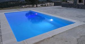 a large blue swimming pool with a stone patio at LA CASONA in Siete Aguas