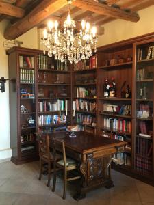 uma sala de jantar com um lustre e prateleiras de livros em Agriturismo Papaveri e Papere em Saludecio
