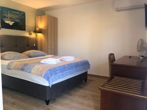 梅杜林Double room with bathroom, WiFi, airco, parking, washing machine, grill的卧室里有一张床，床上放着两条毛巾。