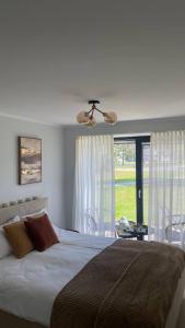 Un dormitorio con una cama grande y una ventana en Three By The Sea apartments at Albatross Home, en Ķesterciems