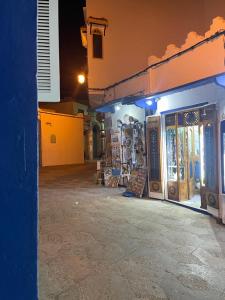 a store front with a blue and orange building at Casa Hassan in Asilah