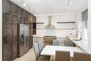 eine Küche mit einem weißen Tisch und Stühlen in der Unterkunft Modern Chelsea Flat, 3Bd 2Bath, with Parking in London