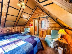 een slaapkamer met een bed en stoelen in een hut bij Off-grid Cabin At Angel Valley Ranch in Duck Creek Village