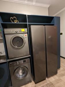 een keuken met een koelkast en een wasmachine bij 1 Elizabeth Place - Luxury Executive Apartment, free Wi-Fi in Midrand