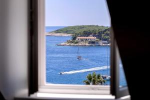 a window view of the ocean with a boat in the water at La Maison - Hvar in Hvar