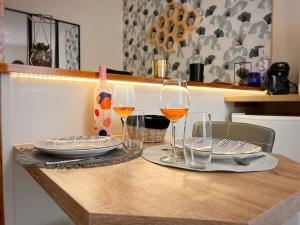 una mesa con copas y platos de vino y una botella en Studio Charmant hyper centre Cognac en Cognac