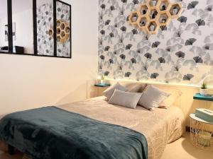 a bedroom with a bed and a wall with at Studio Charmant hyper centre Cognac in Cognac