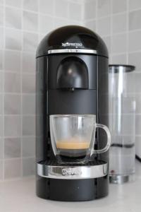 a coffee maker with a cup on a counter at The Clark - Suite 2W - Ocean Grove near Asbury in Ocean Grove