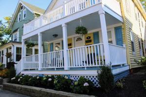 Casa amarilla con porche blanco y barandilla blanca en The Clark - Suite 2W - Ocean Grove near Asbury, en Ocean Grove