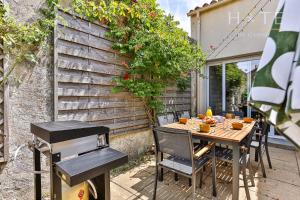 a table with chairs and a grill on a patio at Maison de surfeurs, idéalement située in Les Sables-dʼOlonne
