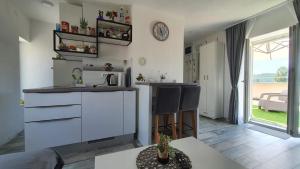 a kitchen and living room with a counter and a table at Apartman Kovačić - Knin in Knin