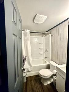 een badkamer met een toilet, een bad en een wastafel bij Glen Garry motel and cottages in North Bay