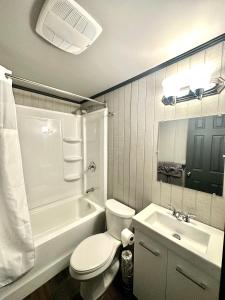 een badkamer met een wit toilet en een wastafel bij Glen Garry motel and cottages in North Bay