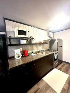 cocina con fregadero y microondas en Glen Garry motel and cottages, en North Bay