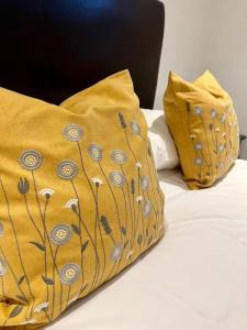 a bed with two yellow pillows on top of it at Spacious 2Bed/2Bath Flat next to London Eye in London