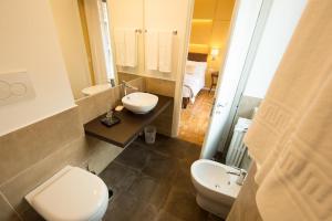 bagno con 2 lavandini, servizi igienici e specchio di B&B Roma 474 a Roma